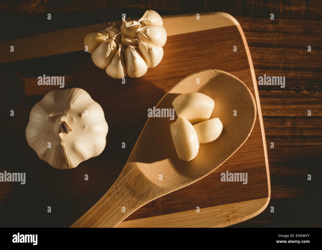 4 spicchi di aglio e la lampadina sul tagliere Foto Stock