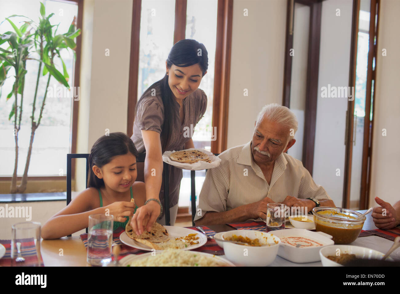 Madre di mettere il cibo sulla piastra figlie Foto Stock