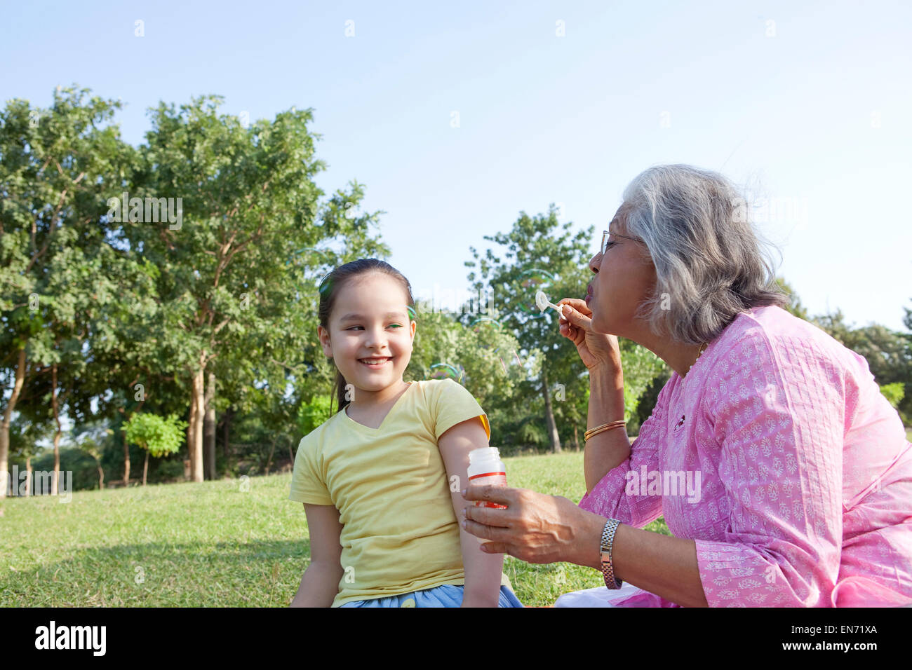Nonna soffiare bolle al nipote Foto Stock