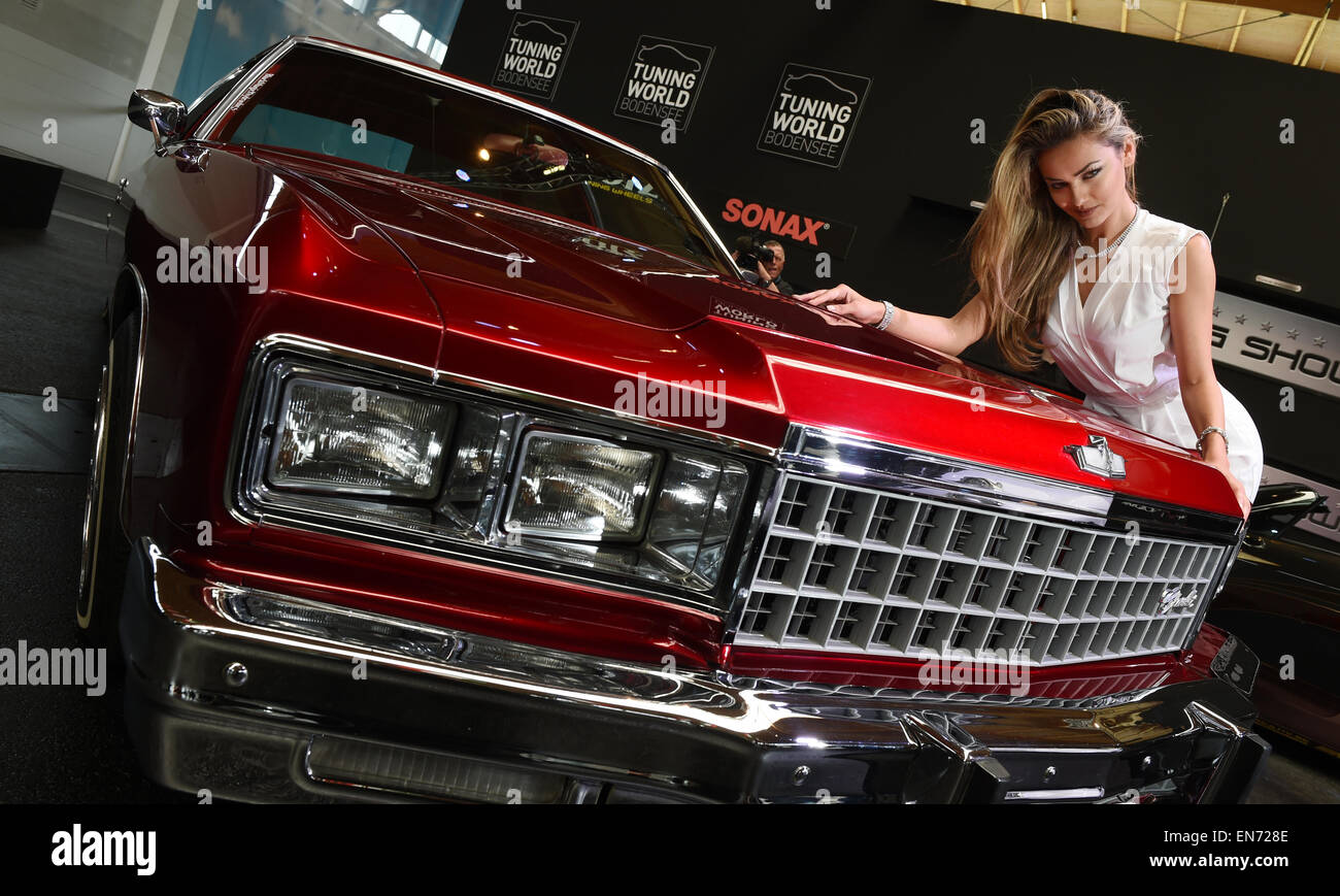 Friedrichshafen, Germania. 29 apr, 2015. Veronika Klimovits, il regnante Miss Tuning, pone da un convertito e sintonizzato Caprice 'Lowrider' da Steve Wuyckens del Belgio un giorno prima della data di inizio del Tuning World Bodensee fiera a Friedrichshafen, Germania, 29 aprile 2015. Foto: FELIX KAESTLE/dpa/Alamy Live News Foto Stock