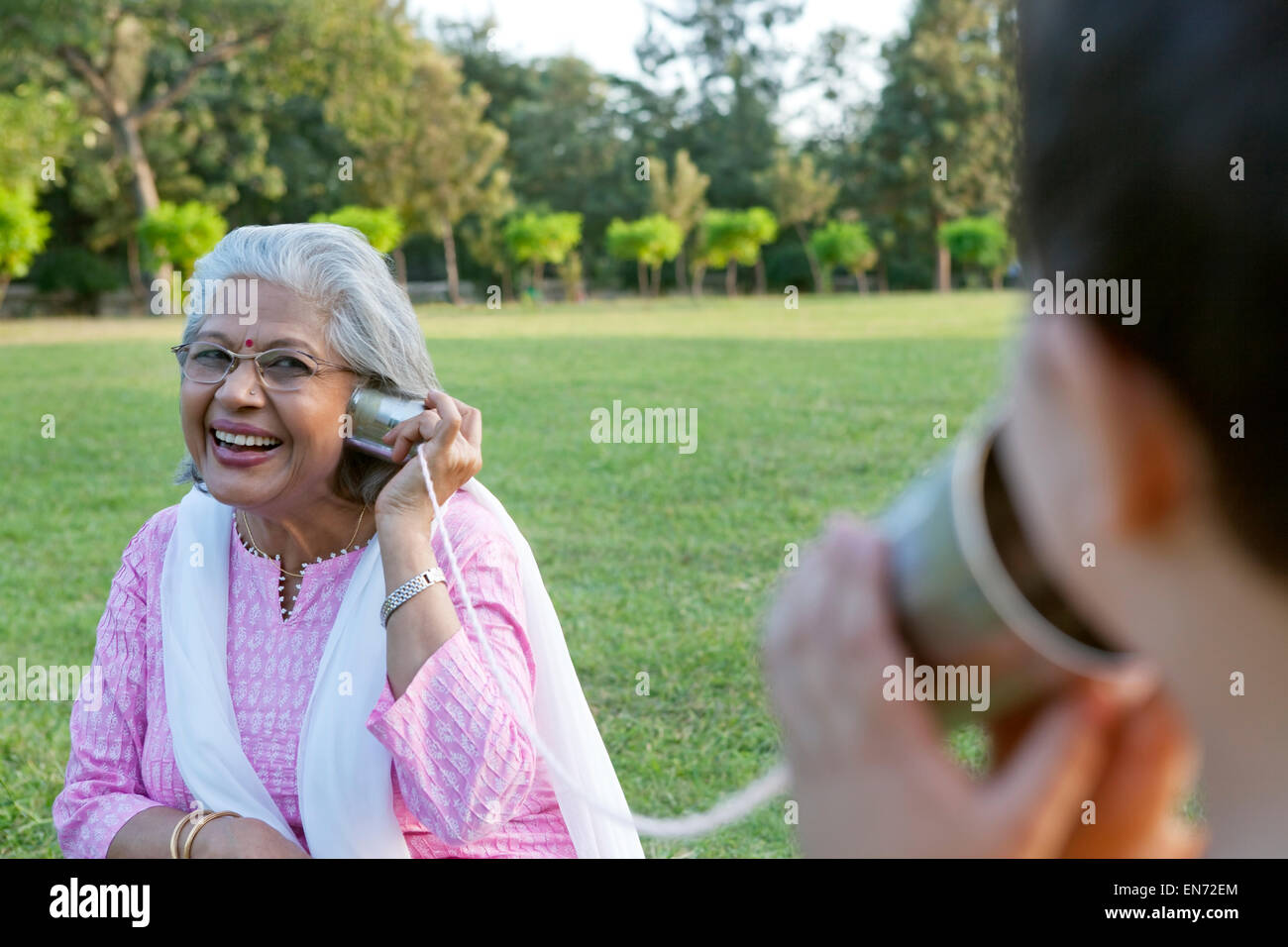 Nonna e nipote di parlare attraverso le lattine di alluminio Foto Stock