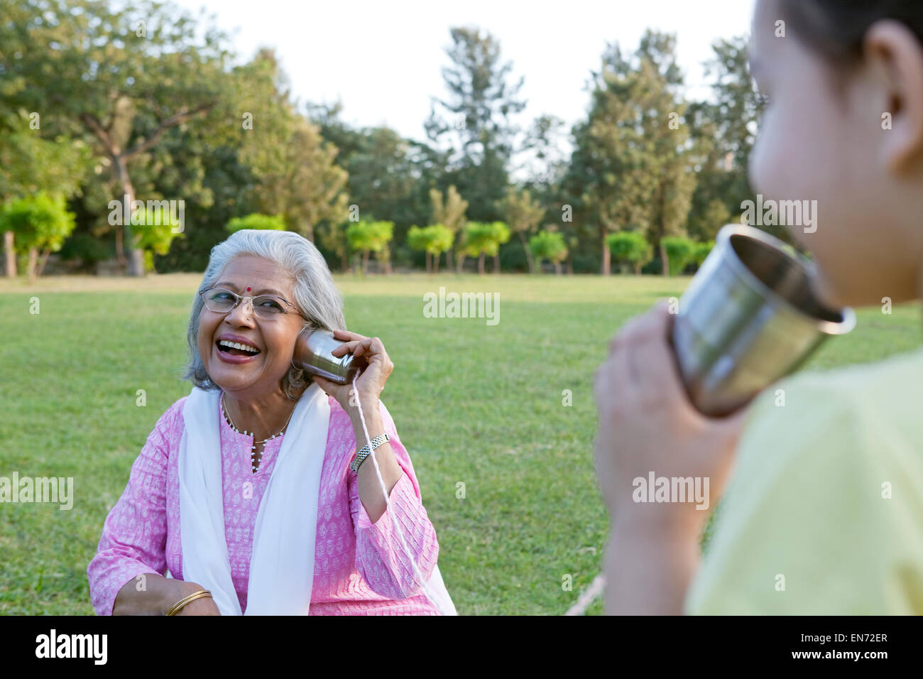 Nonna e nipote di parlare attraverso le lattine di alluminio Foto Stock