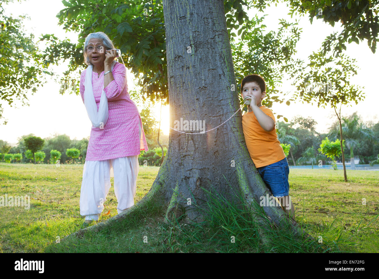 Nonna e nipote di parlare attraverso le lattine di alluminio Foto Stock