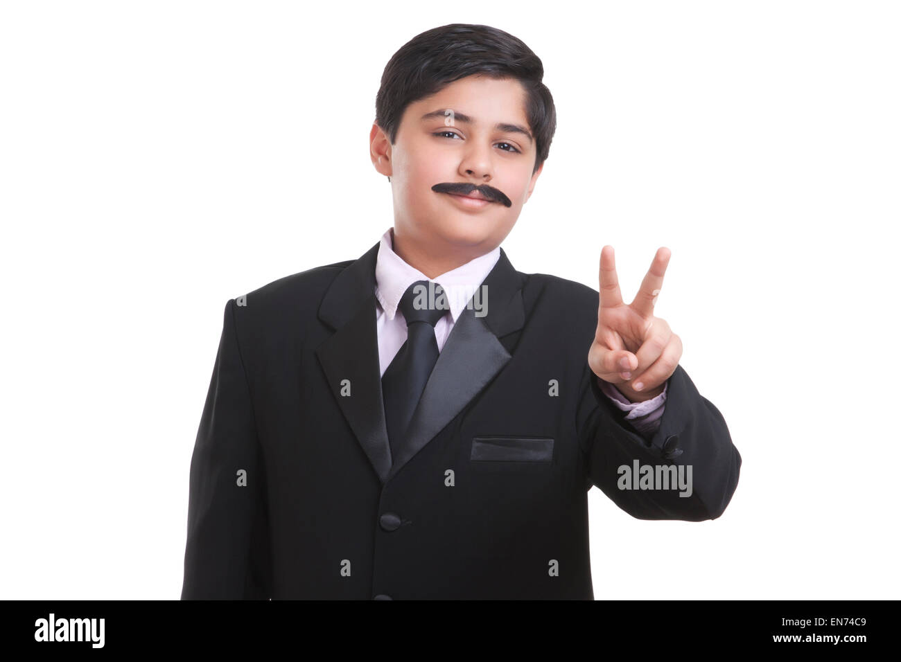 Ritratto di ragazzo vestito da uomo d affari che dà segno di pace Foto Stock