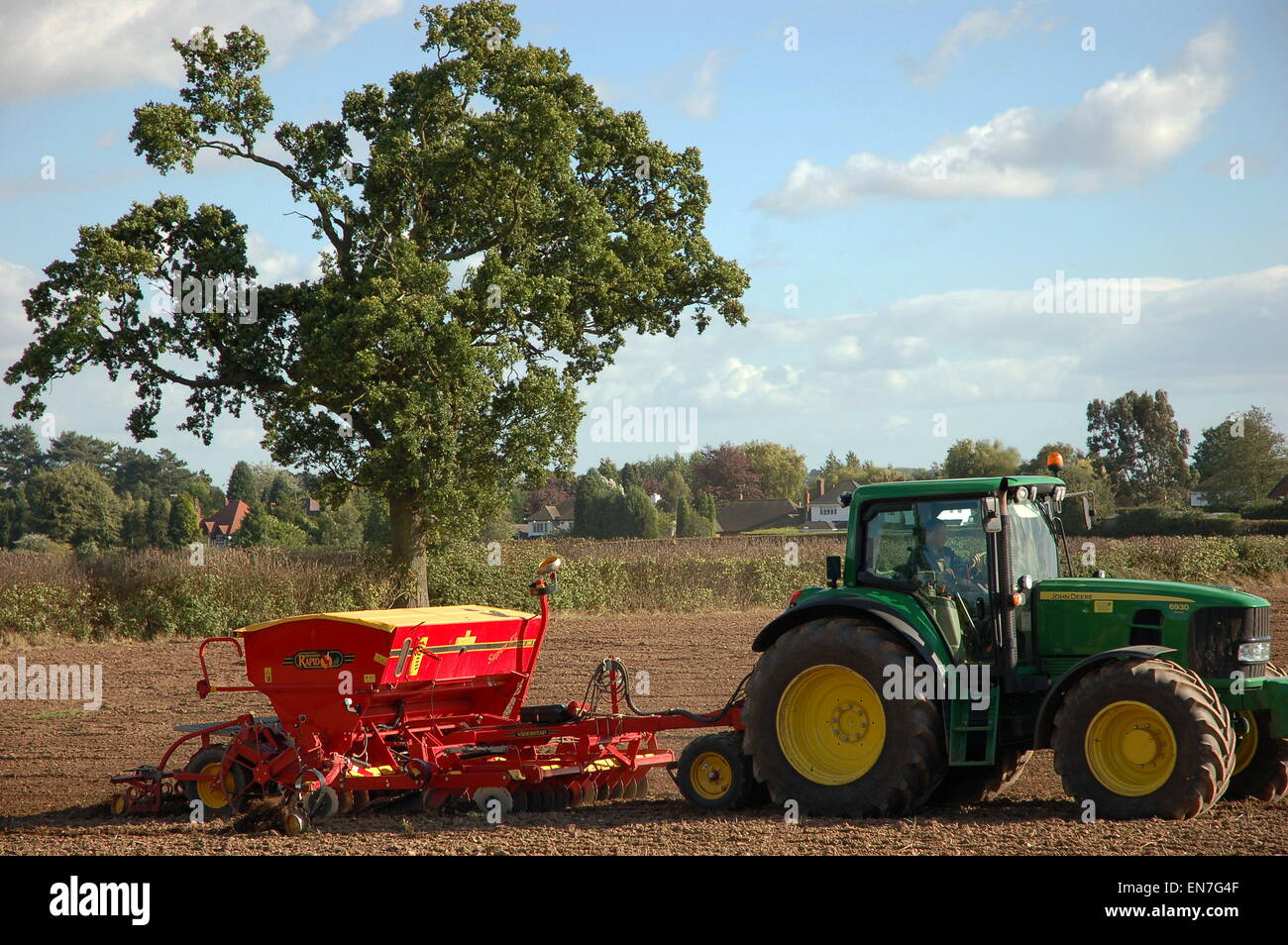 Un 'John Deere trattore delle colture di piante in un campo alla periferia di Perton nel South Staffordshire. Foto Stock