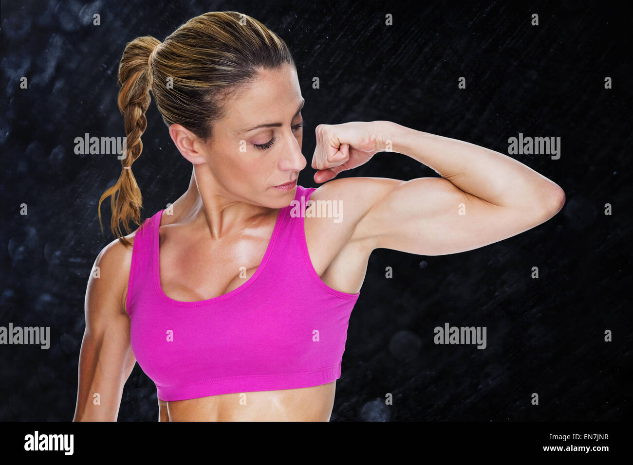 Immagine composita di bodybuilder femminile flessione bicipite in rosa reggiseno per lo sport Foto Stock