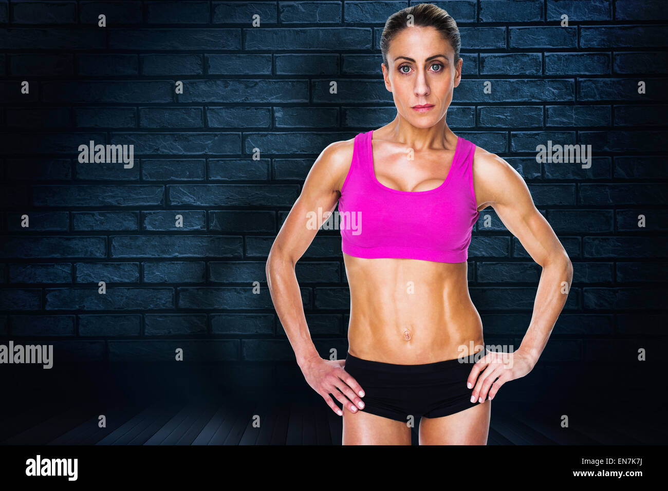 Immagine composita di bodybuilder femminile in posa con le mani sui fianchi guardando la fotocamera Foto Stock