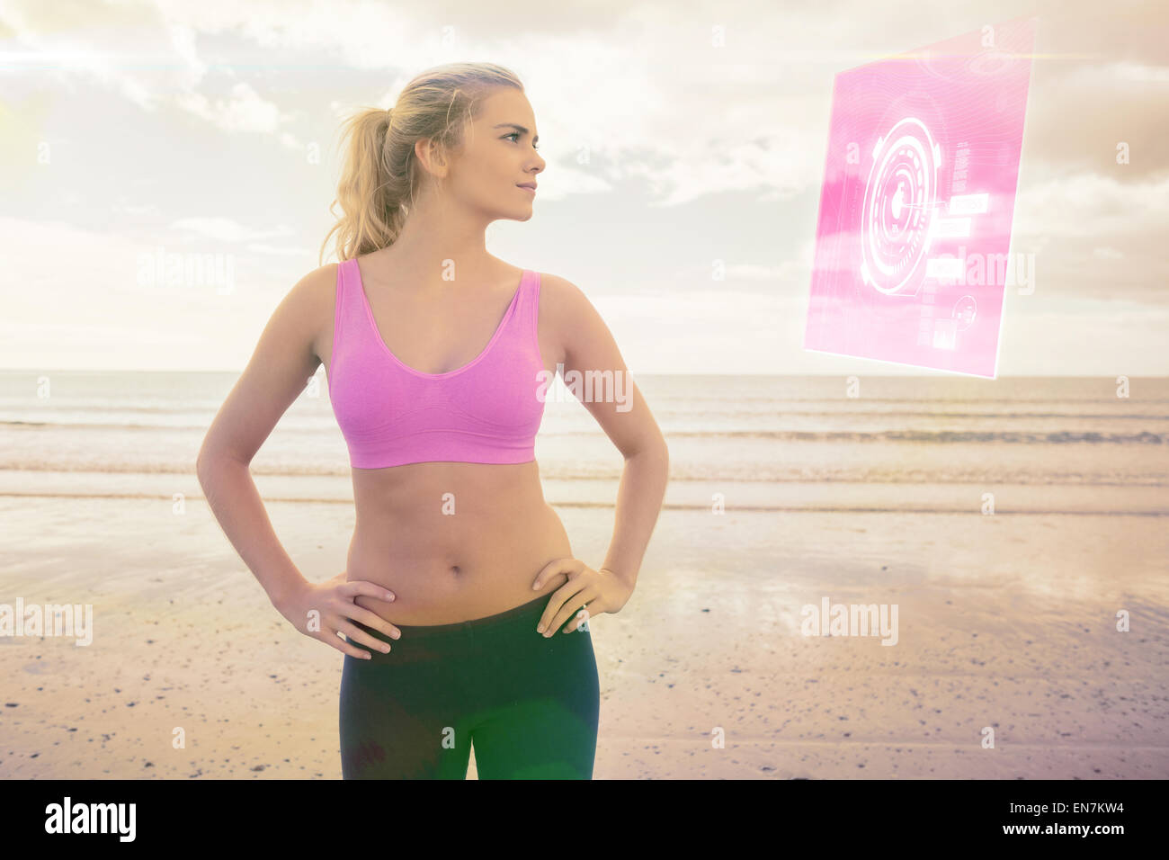 Immagine composita della tonica donna con le mani sui fianchi sulla spiaggia Foto Stock