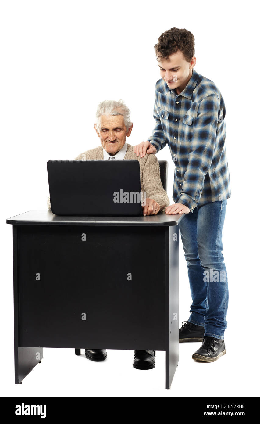 Ragazzo adolescente insegnamento suo nonno come usare un computer portatile Foto Stock