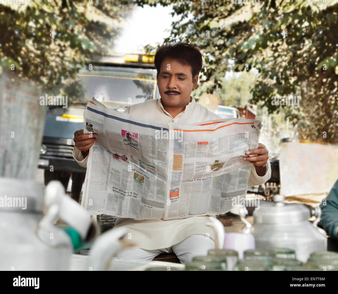 L'uomo leggendo un giornale al tè in stallo Foto Stock