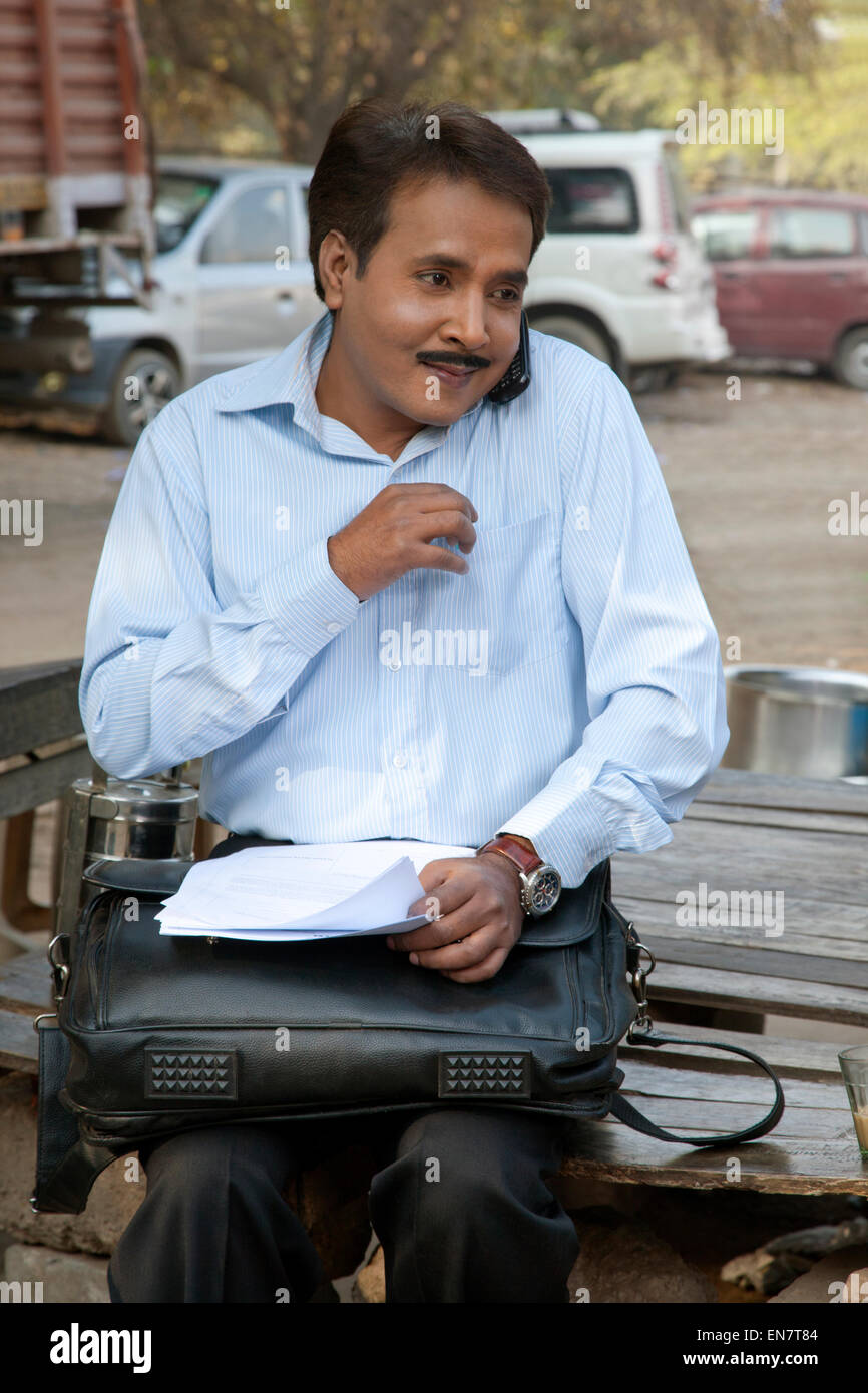 Venditore a parlare su un telefono mobile e sorridente Foto Stock