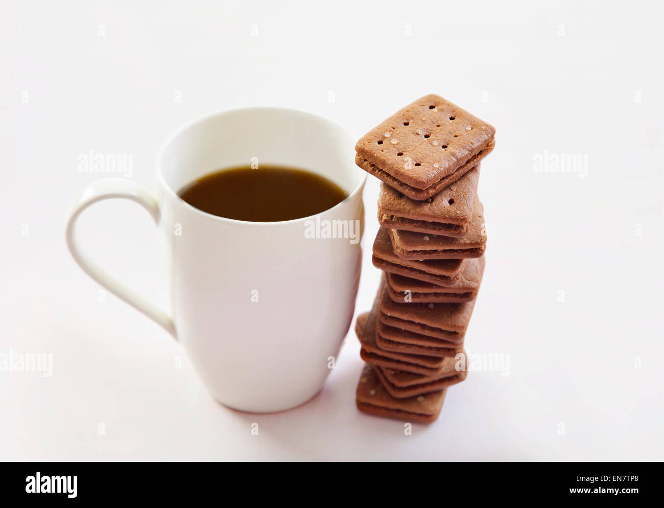 Tazza da caffè con la pila di biscotti su sfondo bianco Foto Stock