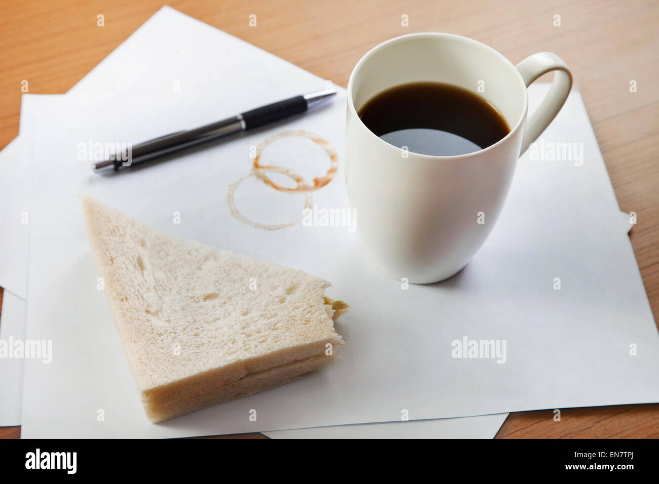 Il caffè e il panino sulla scrivania Foto Stock
