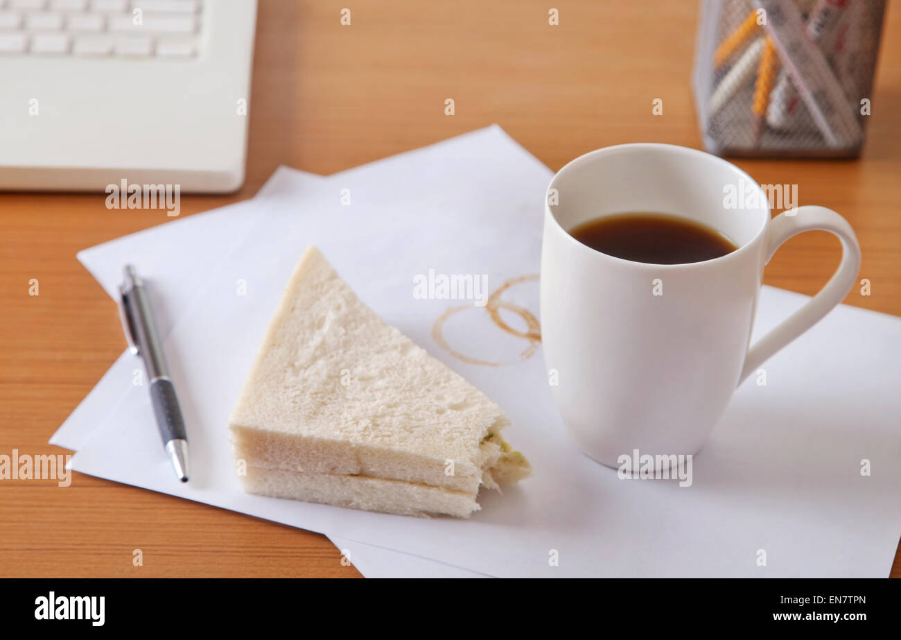 Il caffè e il panino sulla scrivania Foto Stock