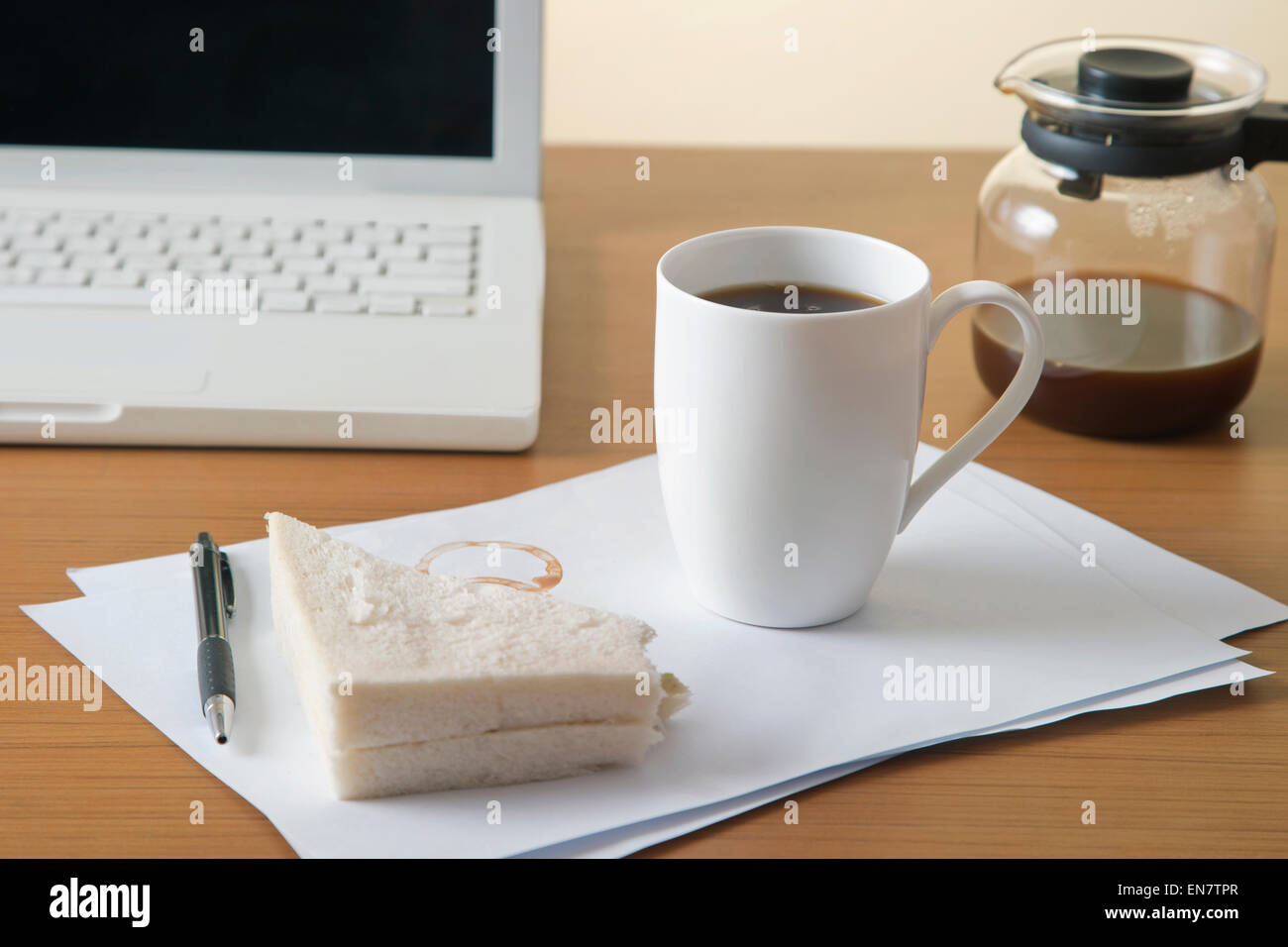 Il caffè e il panino sulla scrivania Foto Stock