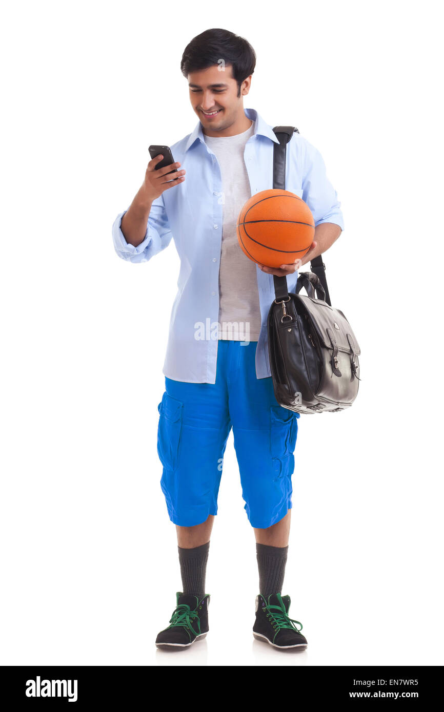 Ritratto di giovane uomo con valigetta e basket utilizzando il telefono cellulare Foto Stock