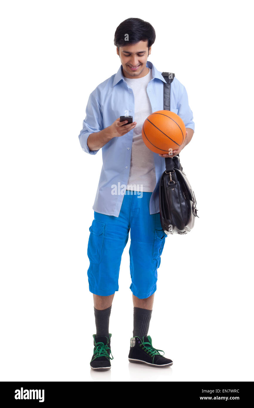 Ritratto di giovane uomo con valigetta e basket utilizzando il telefono cellulare Foto Stock