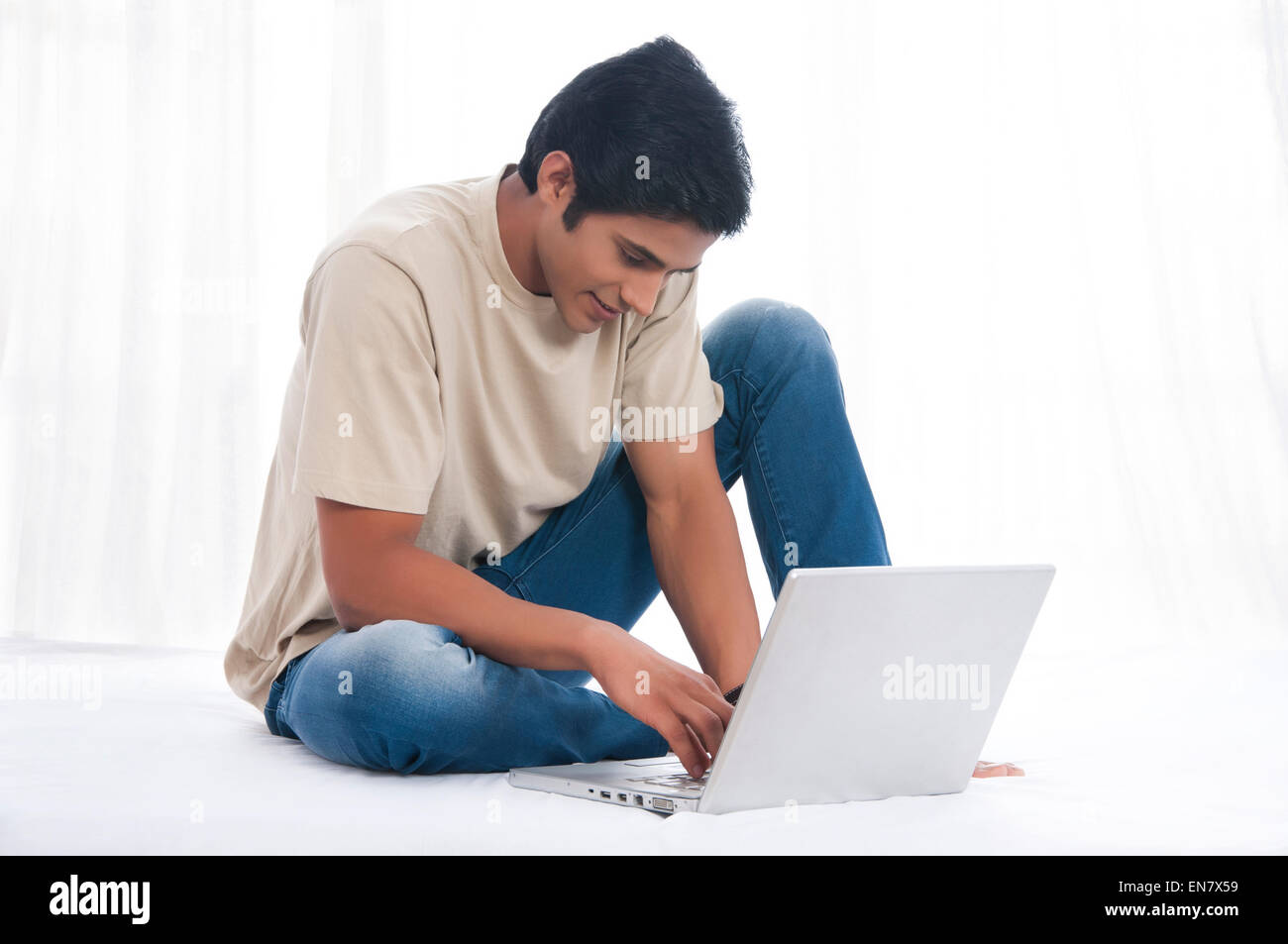 Giovane uomo che lavora sul computer portatile Foto Stock