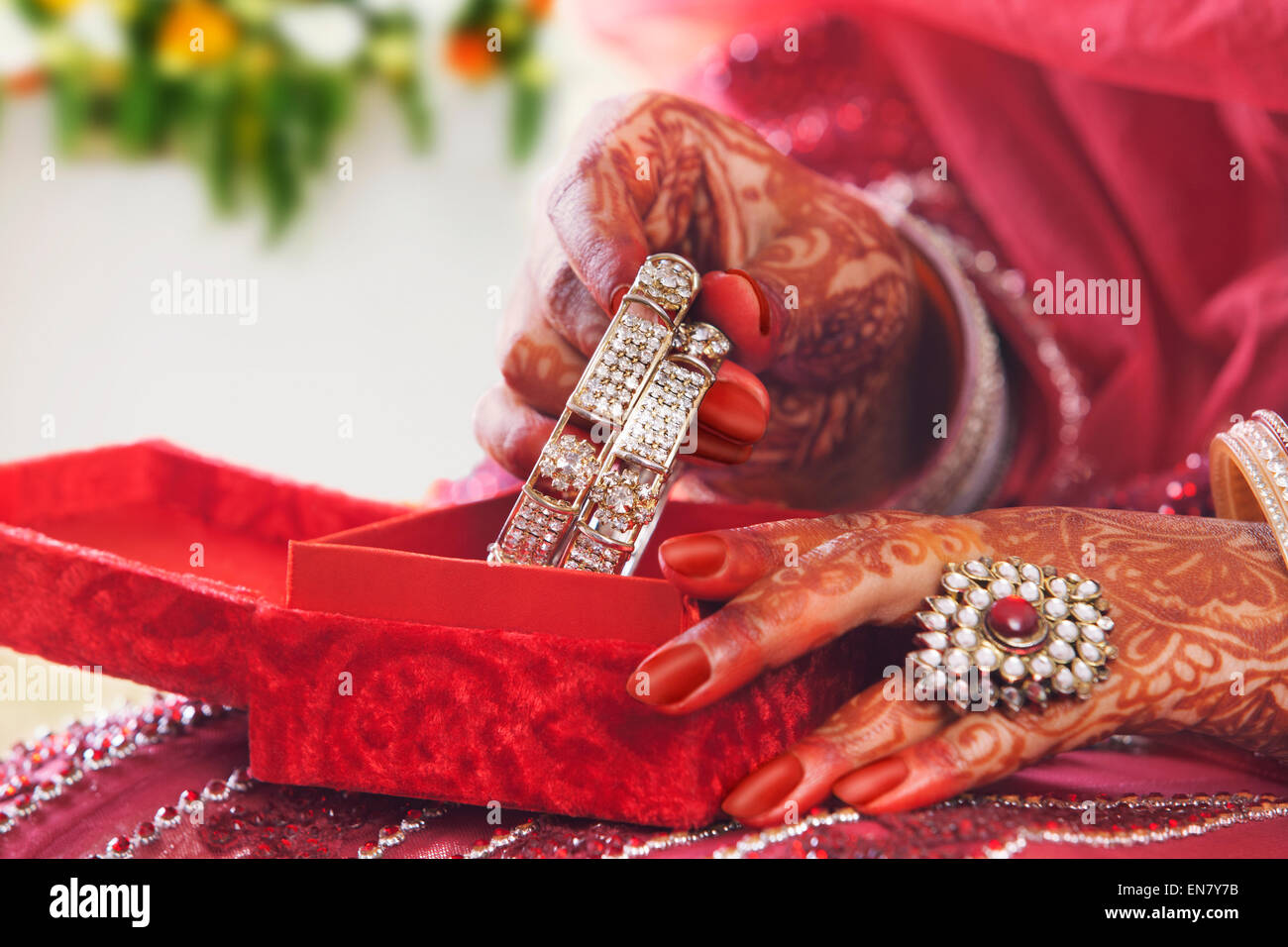 Close-up di spose ponendo le mani schiave in bangle box Foto Stock