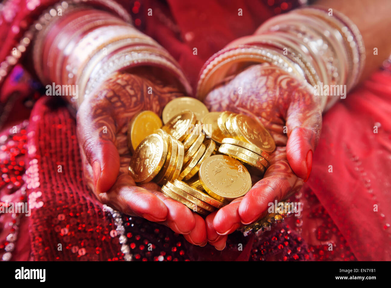 Primo piano di una Brides mani tenendo le monete d'oro Foto Stock