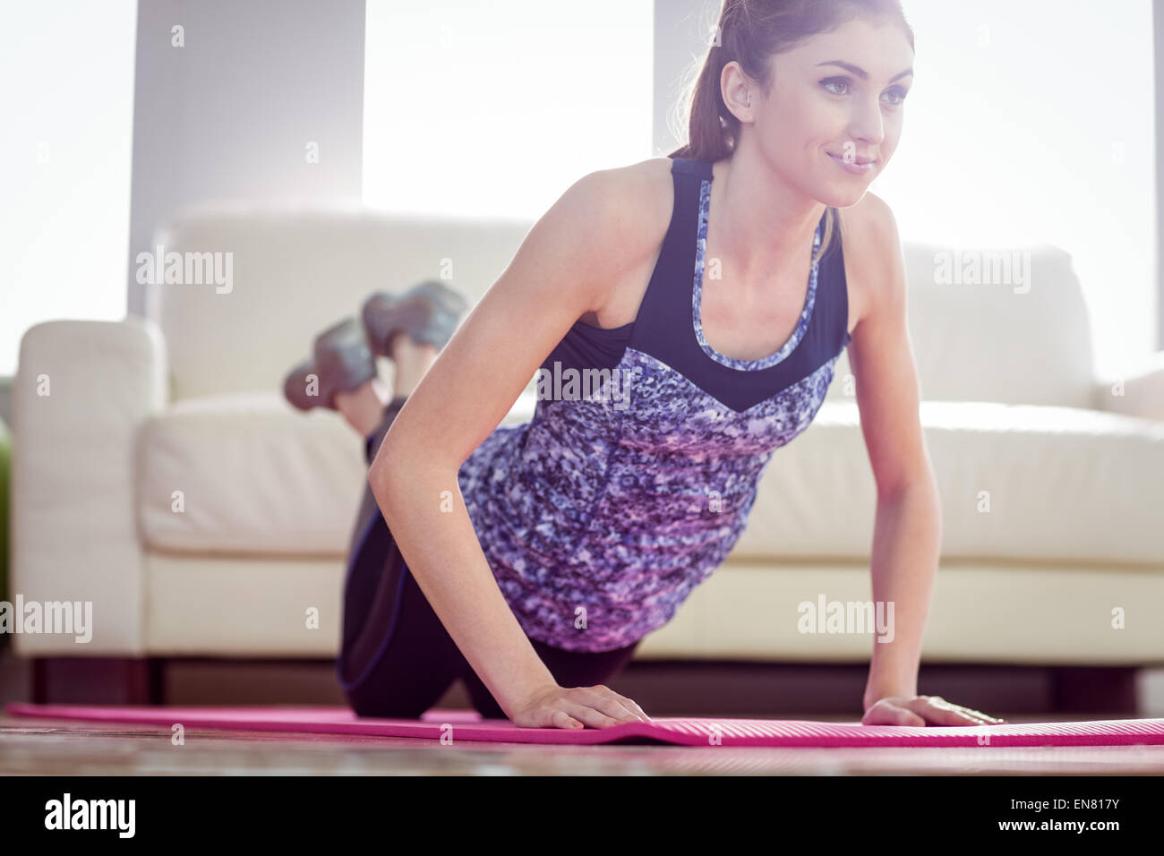 Montare la donna facendo premere up sul tappeto di esercizio Foto Stock