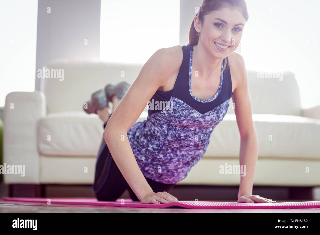 Montare la donna facendo premere up sul tappeto di esercizio Foto Stock