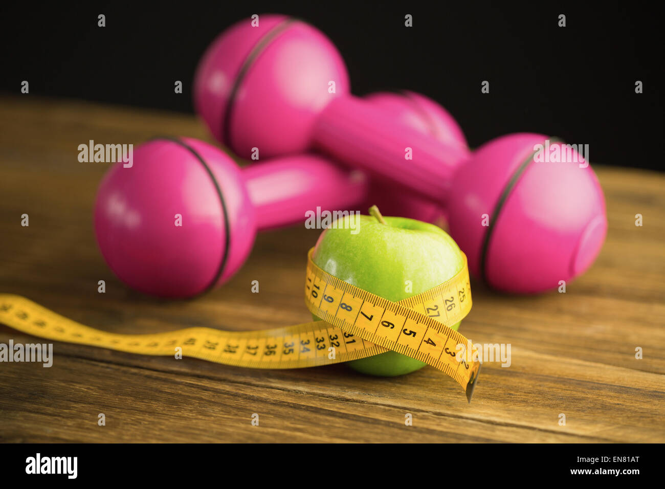 Rosa manubri con mela verde e nastro di misurazione Foto Stock