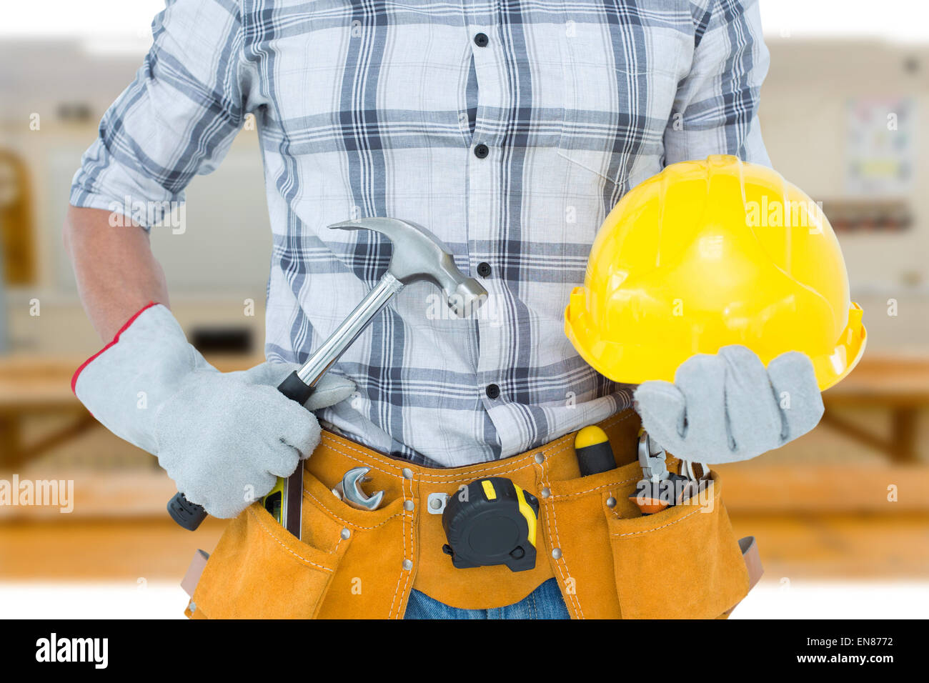 Immagine composita di tuttofare azienda martello e un elmetto Foto Stock