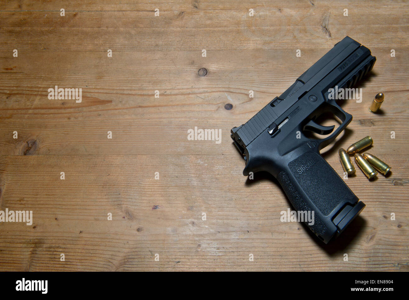 Un Sig P250 pistola semiautomatica con i suoi 9mm.parabellum munizioni,suggerendo omicidio,mistero,morte,uccidendo,pistola,le riprese Foto Stock