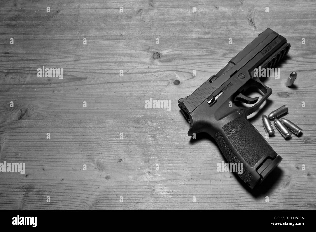 Un Sig P250 pistola semiautomatica con i suoi 9mm.parabellum munizioni,suggerendo omicidio,mistero,morte,uccidendo,pistola,le riprese Foto Stock