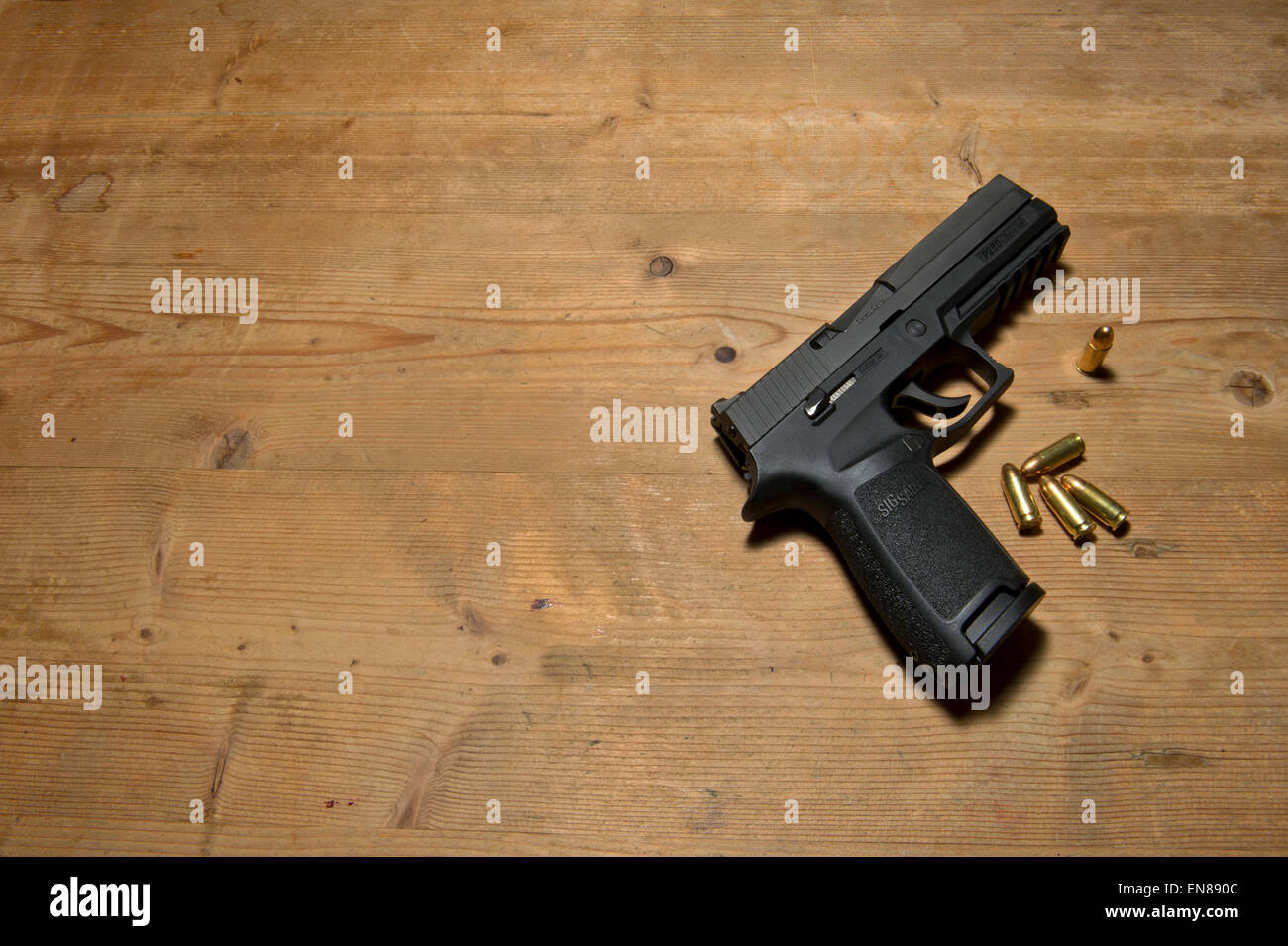 Un Sig P250 pistola semiautomatica con i suoi 9mm.parabellum munizioni,suggerendo omicidio,mistero,morte,uccidendo,pistola,le riprese Foto Stock