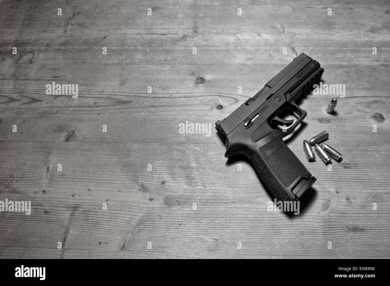 Un Sig P250 pistola semiautomatica con i suoi 9mm.parabellum munizioni,suggerendo omicidio,mistero,morte,uccidendo,pistola,le riprese Foto Stock