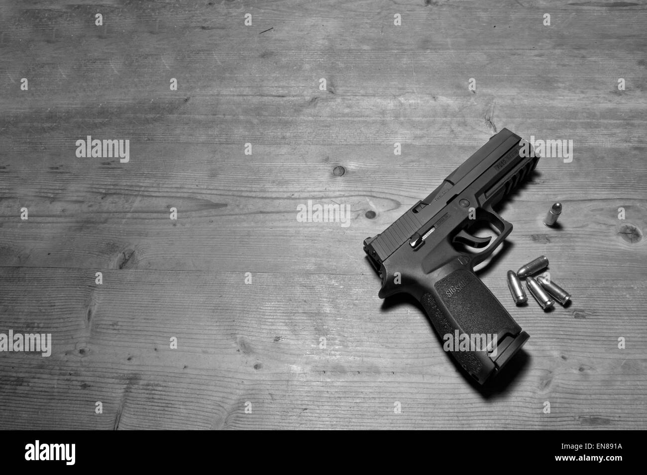 Un Sig P250 pistola semiautomatica con i suoi 9mm.parabellum munizioni,suggerendo omicidio,mistero,morte,uccidendo,pistola,le riprese Foto Stock