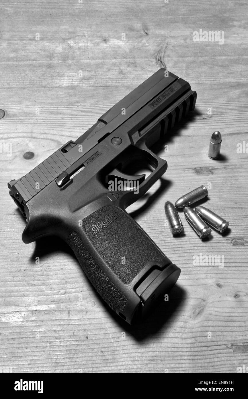 Un Sig P250 pistola semiautomatica con i suoi 9mm.parabellum munizioni,suggerendo omicidio,mistero,morte,uccidendo,pistola,le riprese Foto Stock