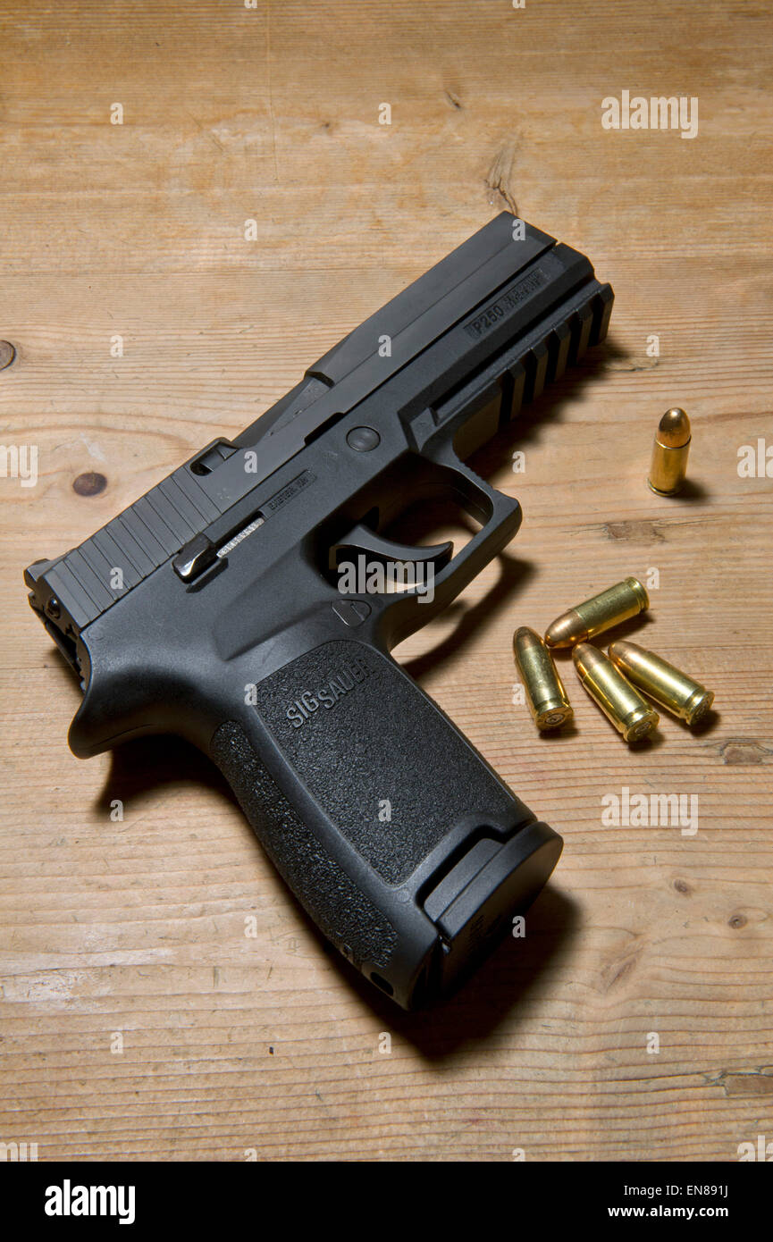 Un Sig P250 pistola semiautomatica con i suoi 9mm.parabellum munizioni,suggerendo omicidio,mistero,morte,uccidendo,pistola,le riprese Foto Stock