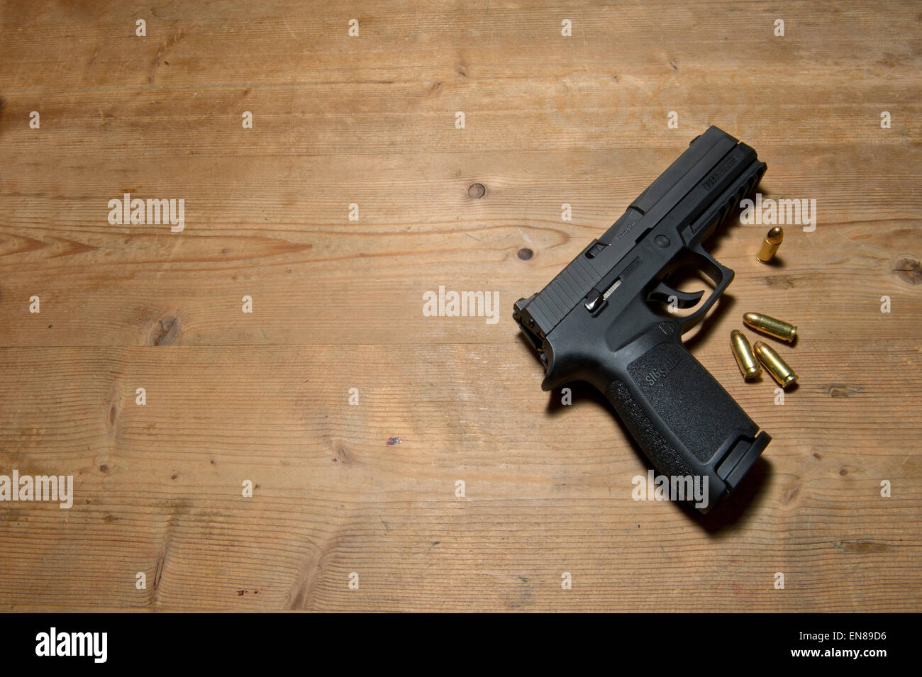 Un Sig P250 pistola semiautomatica con i suoi 9mm.parabellum munizioni,suggerendo omicidio,mistero,morte,uccidendo,pistola,le riprese Foto Stock