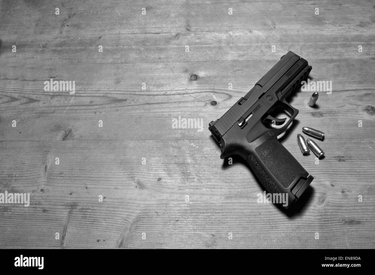 Un Sig P250 pistola semiautomatica con i suoi 9mm.parabellum munizioni,suggerendo omicidio,mistero,morte,uccidendo,pistola,le riprese Foto Stock