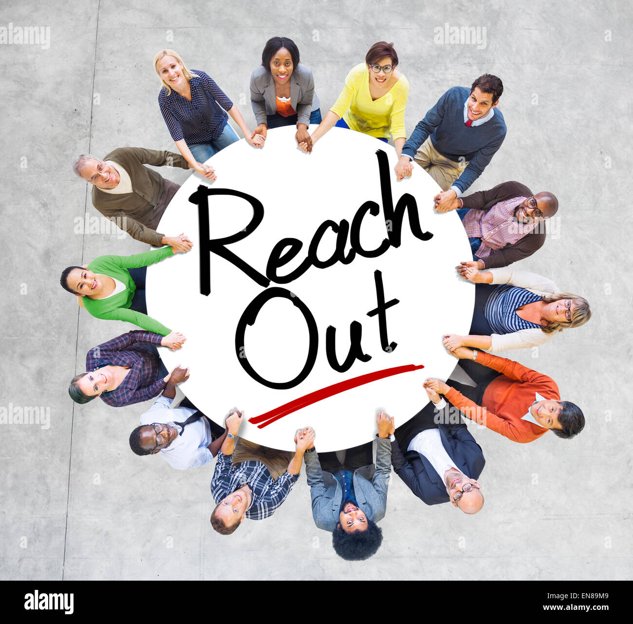 Gruppo di persone che si tengono per mano intorno alla Parola Reach Out Foto Stock