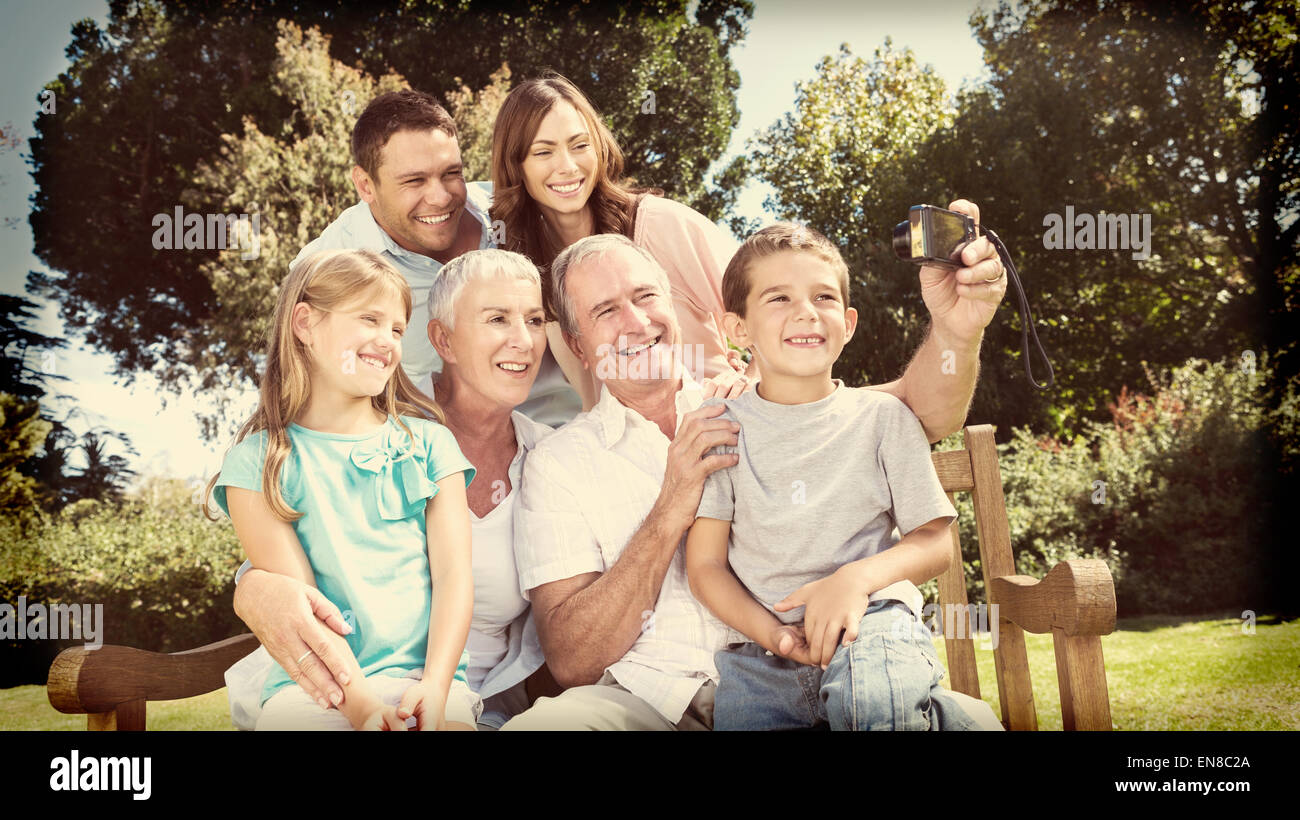 Famiglia seduta su una panchina di prendere foto di se stessi Foto Stock