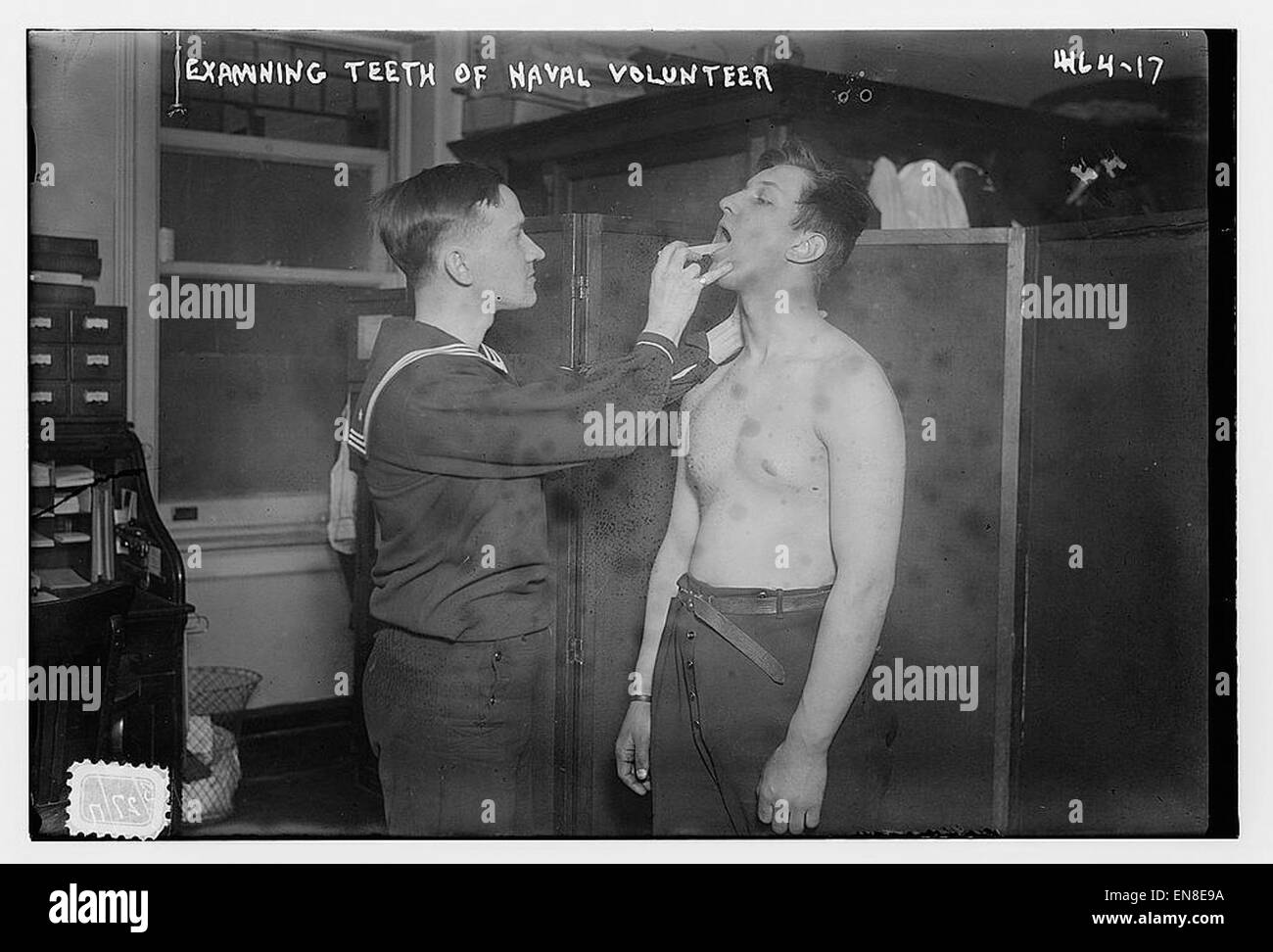 Questa immagine raffigura un volontario navale che ha esaminato i denti, probabilmente come parte di una valutazione medica o di un controllo sanitario di routine per il personale militare. L’attenzione è rivolta alla salute e alla disponibilità al servizio dell’individuo. Foto Stock