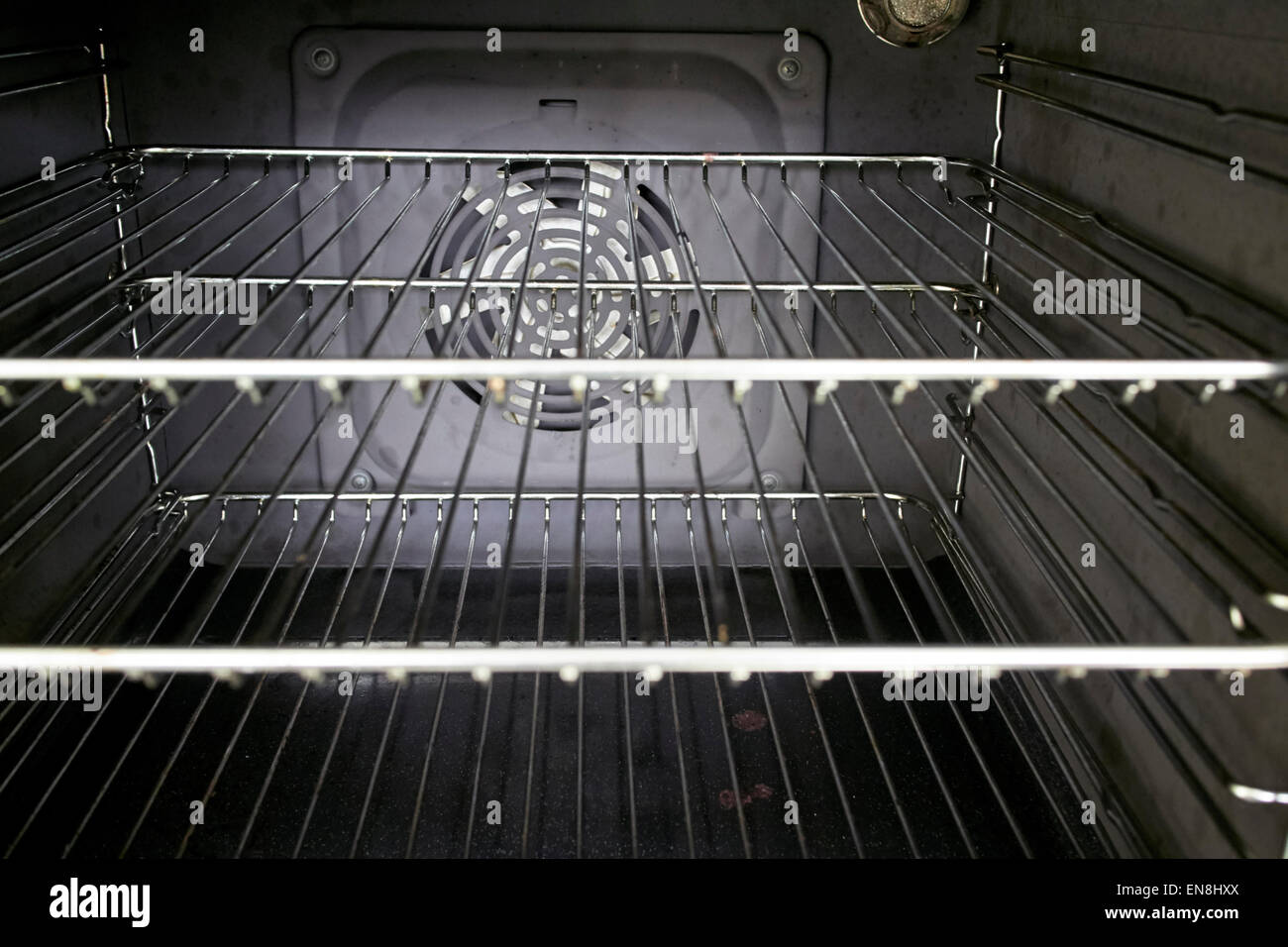 Interno di una cucina domestica con ventilatore forno a pulire la griglia in metallo ripiani Foto Stock