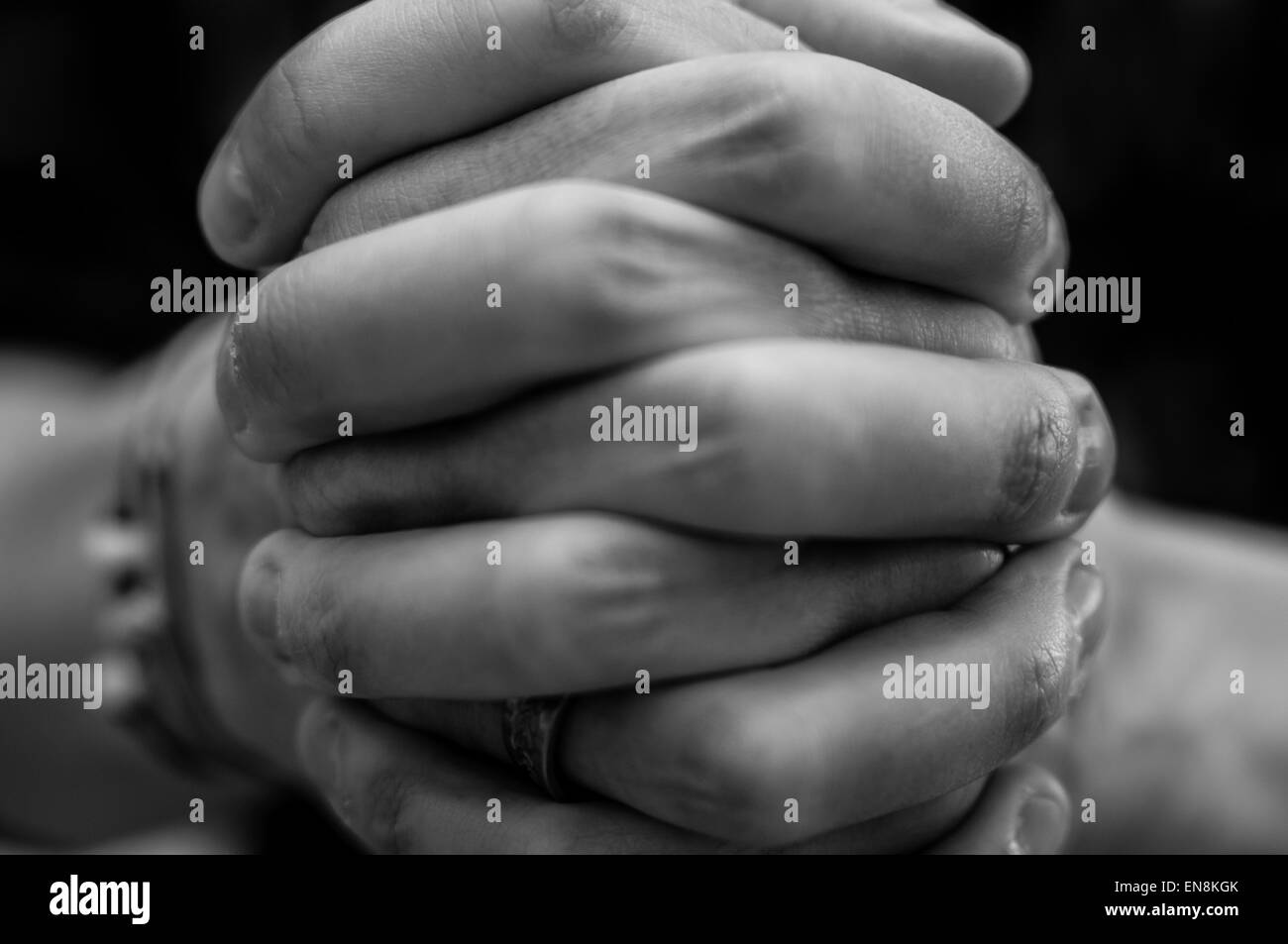 In bianco e nero di close-up di mani rinserrata insieme, illustrante una preghiera Foto Stock