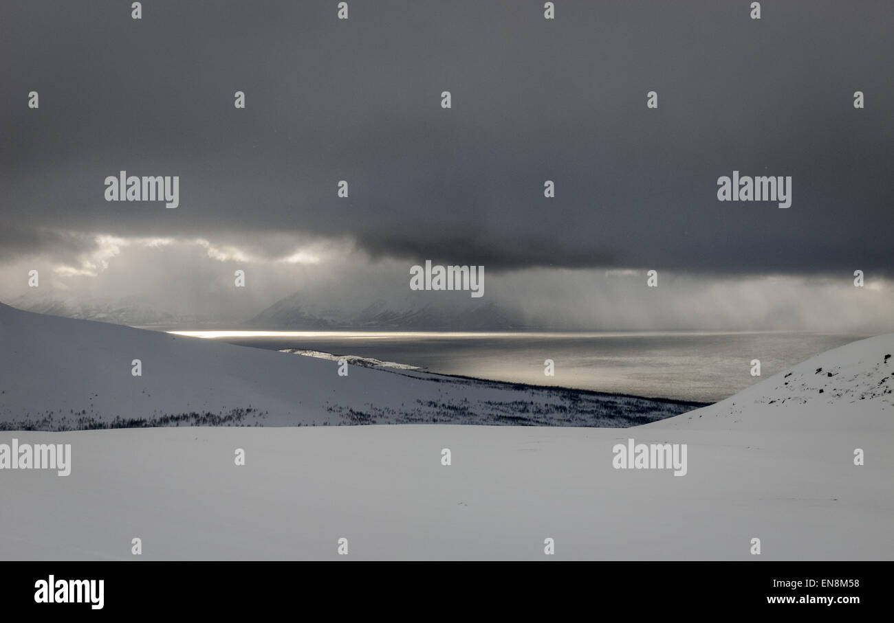 Nuvole di tempesta (con una fodera argentata) su montagne e fiordi, Alpi Lyngen, Norvegia artica Foto Stock