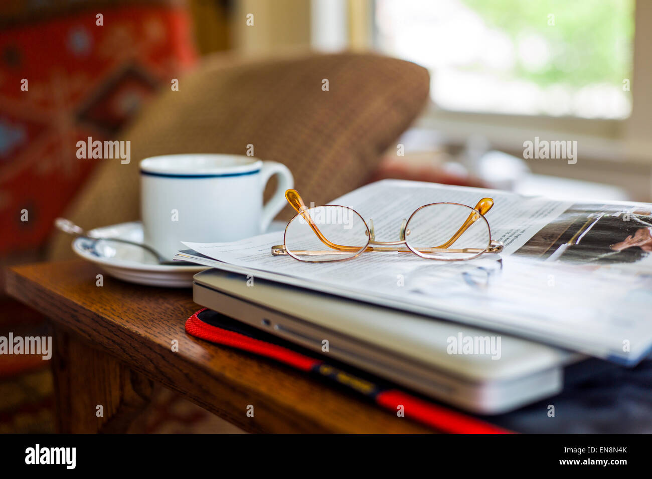 Still Life studio della tazza e piattino, gli occhiali da lettura, la rivista e il computer portatile Foto Stock