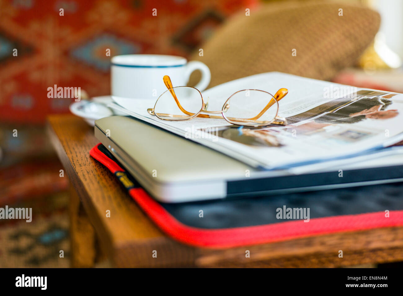 Still Life studio della tazza e piattino, gli occhiali da lettura, la rivista e il computer portatile Foto Stock