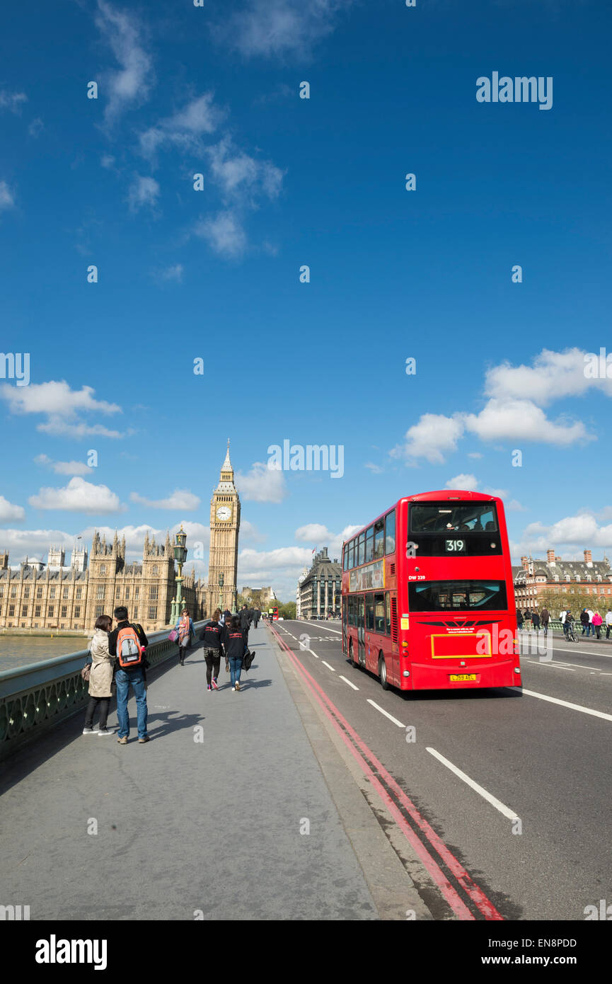 LONDON, Regno Unito - 27 Aprile 2015: pedoni passano autobus sul Westminster Bridge nella parte anteriore del Big Ben e le Camere del Parlamento. Foto Stock
