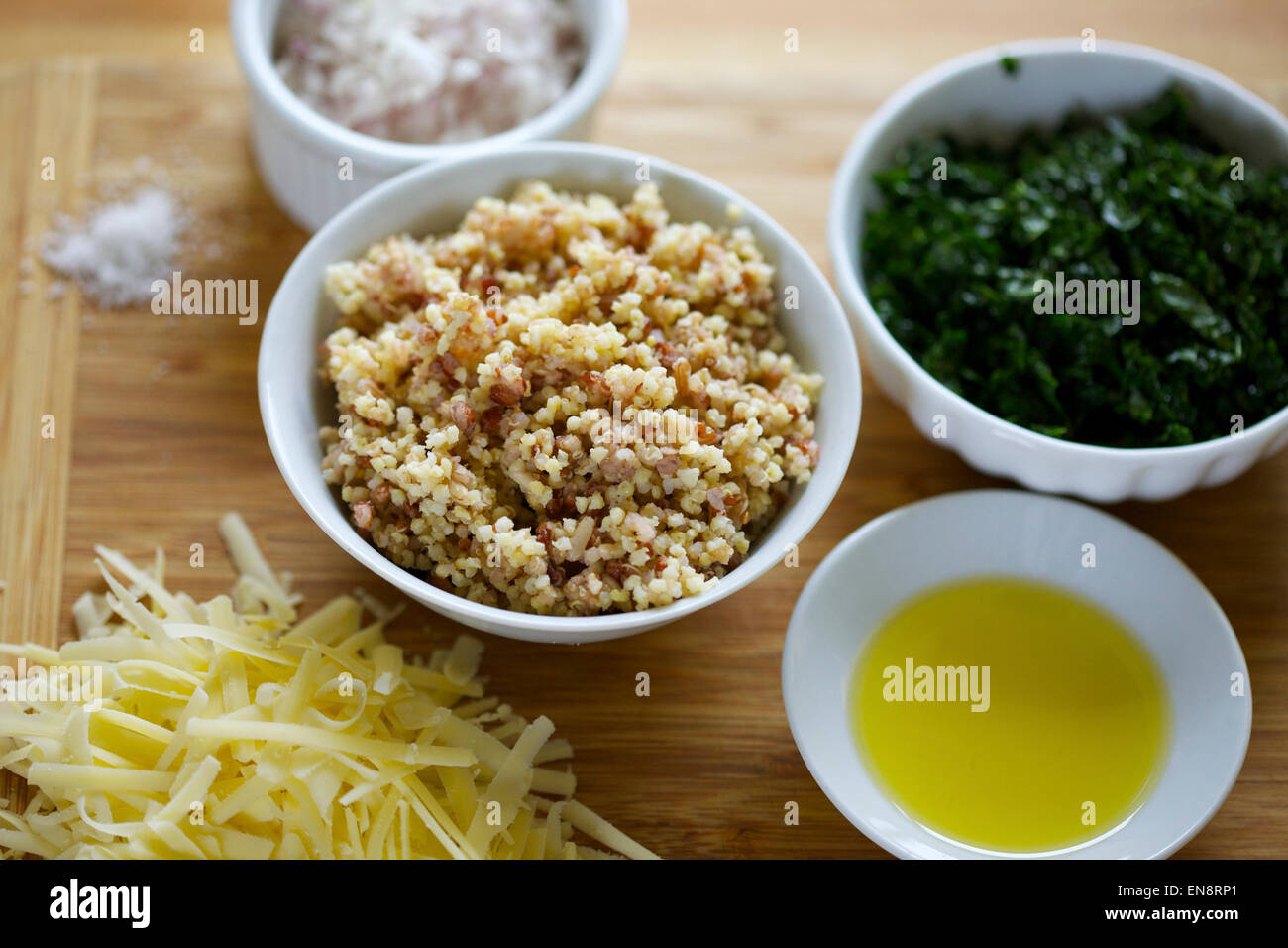 Bocce di ingredienti preparati compresi cotta la quinoa, tritato cavolo riccio, cipolla tritata, formaggio grattugiato, olio di oliva e un pizzico di sale. Foto Stock