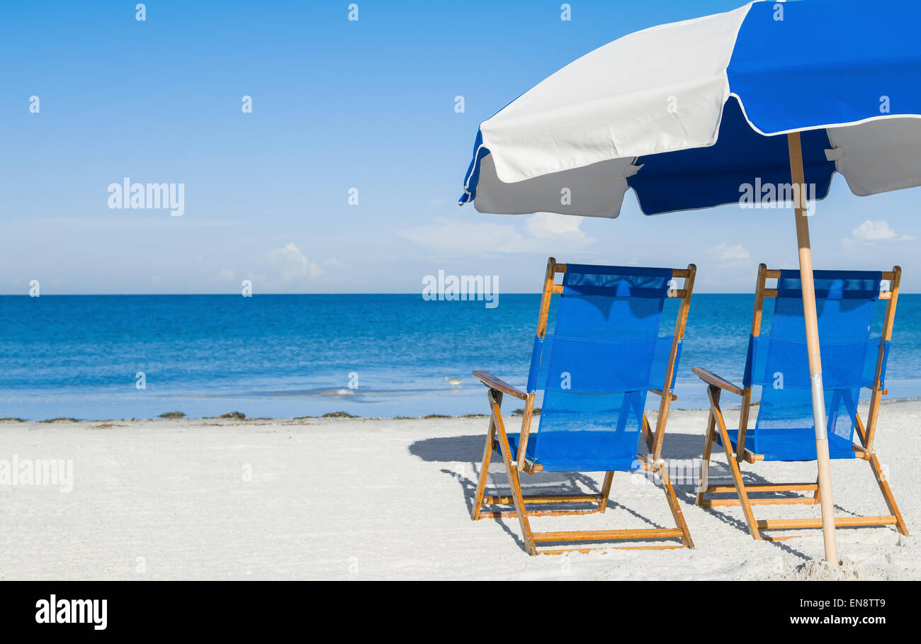 Sedie a sdraio e un ombrellone sulla sabbia di argento, concetto di vacanza Foto Stock