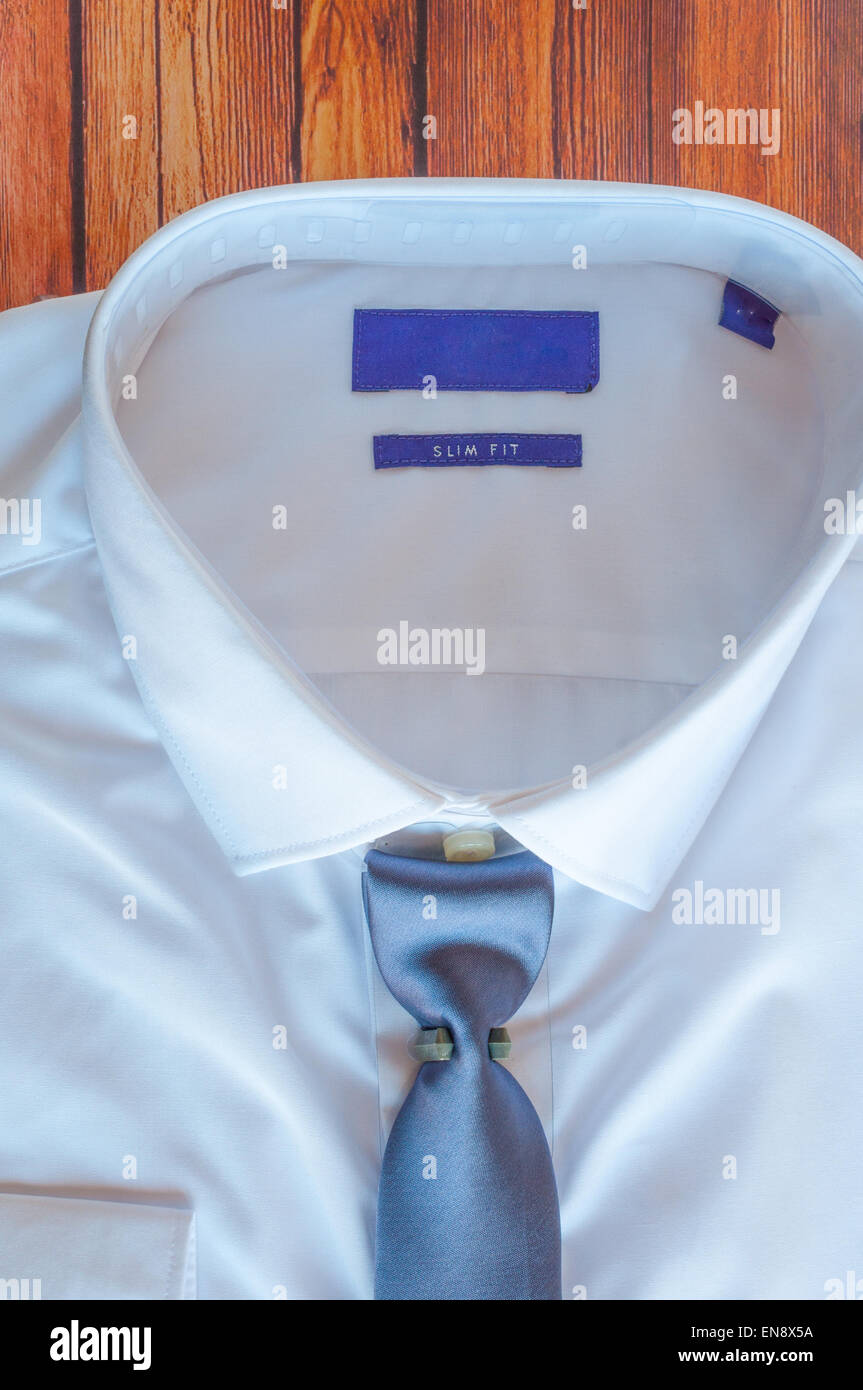 Camicia bianca con cravatta blu su sfondo di legno Foto Stock