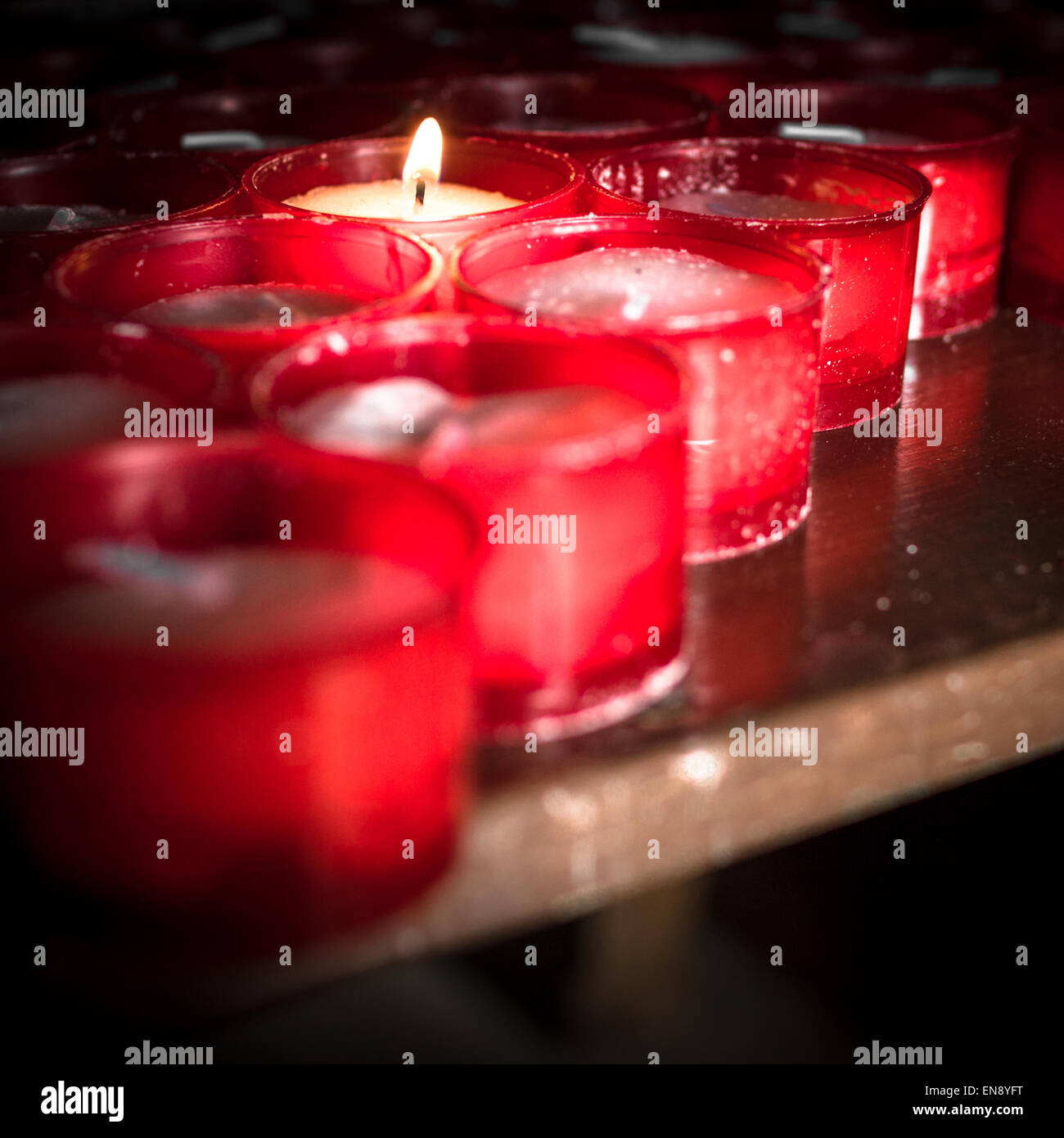 Gruppo di candele rosse in una chiesa. Foto Stock